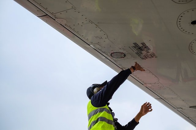 A Mor Air staff with a safety vest on working on a cooling unit outside