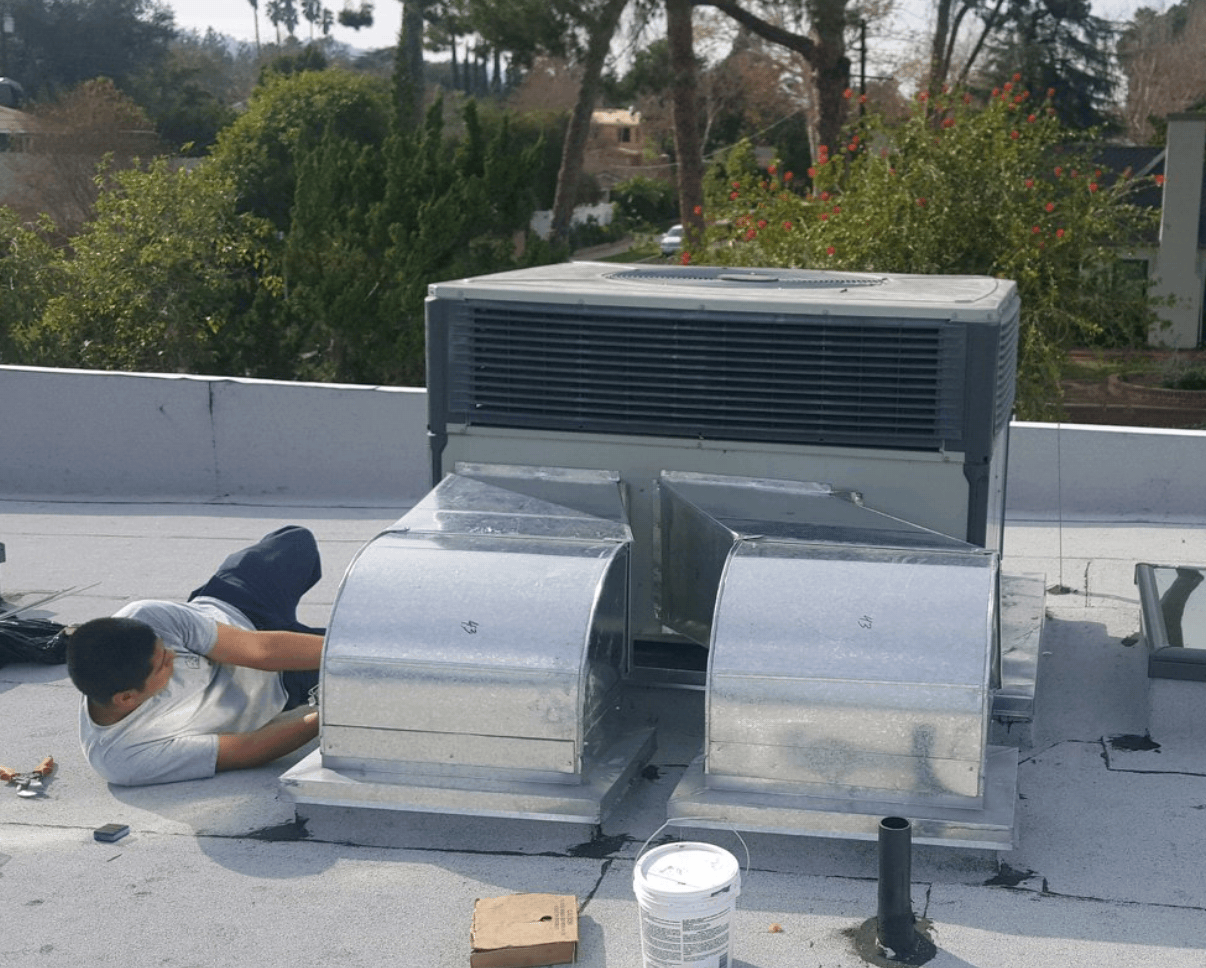 Mor Air staff on the ground working on an air conditioning unit outdoors